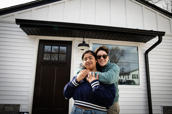 Iliana Damascena hugs her new wife, Yara, in front of the door to their new home in Cranston, Rhode Island.